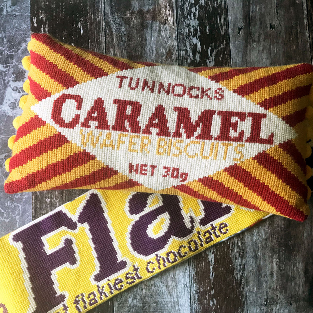 Tunnock's Caramel Wafers biscuit cross stitch wool and flack tuck shop copyright jacqui pearceon a wooden surface