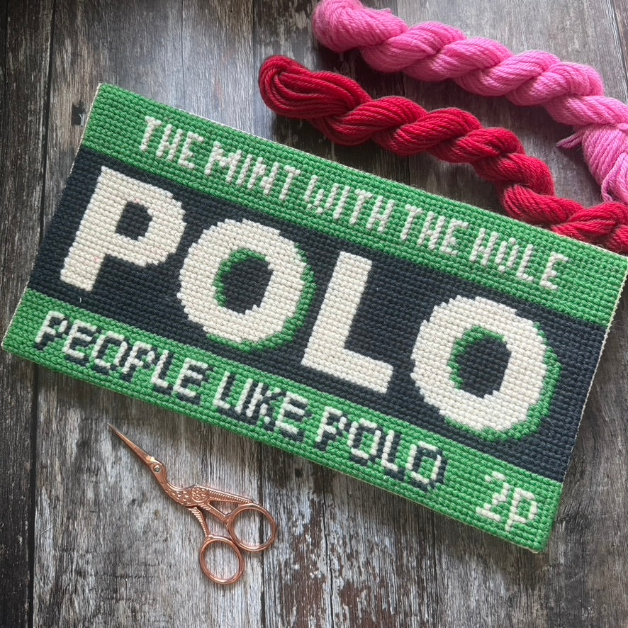 Polo mint Embroidered patch with text and yarn on a wooden surface